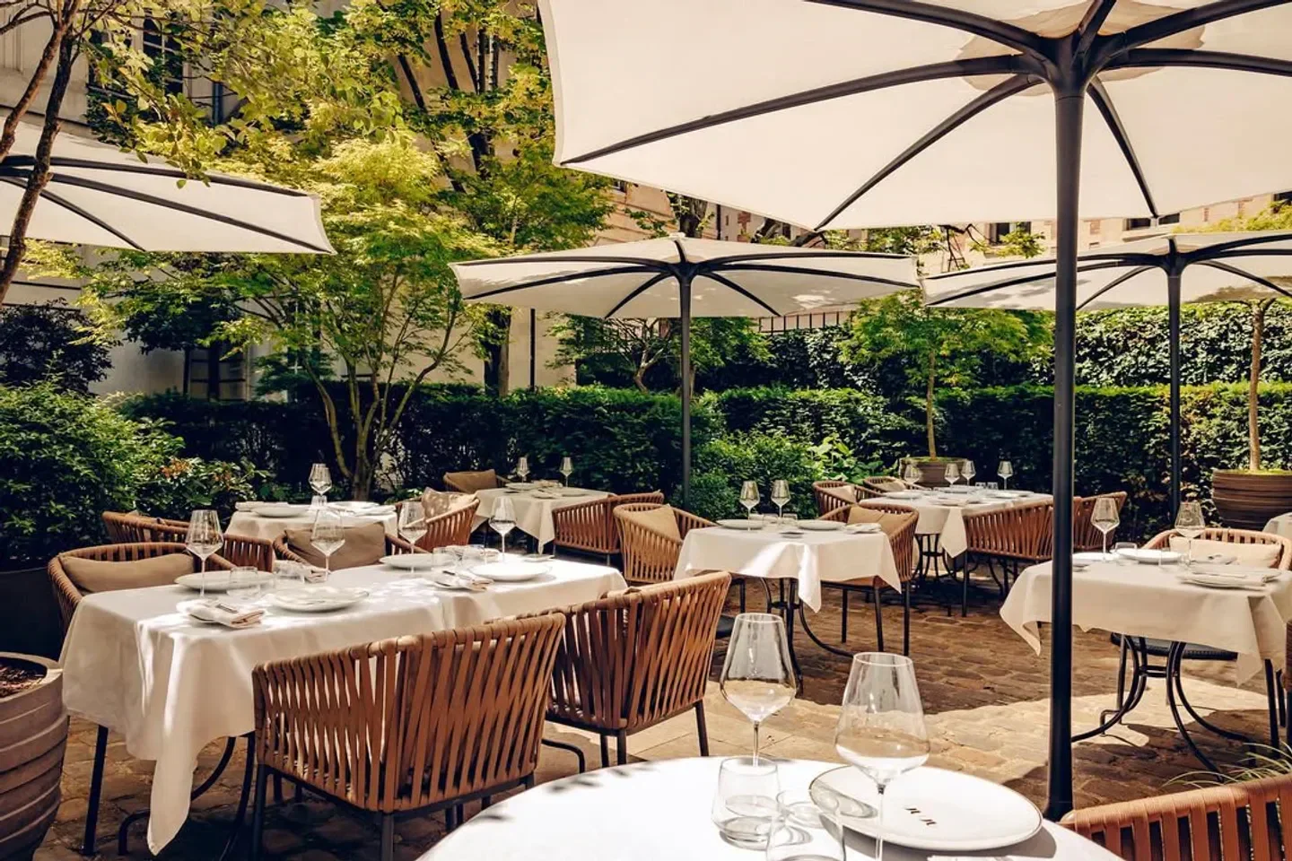 Outdoor dining at Anne restaurant in Paris, featuring umbrellas and elegant tables