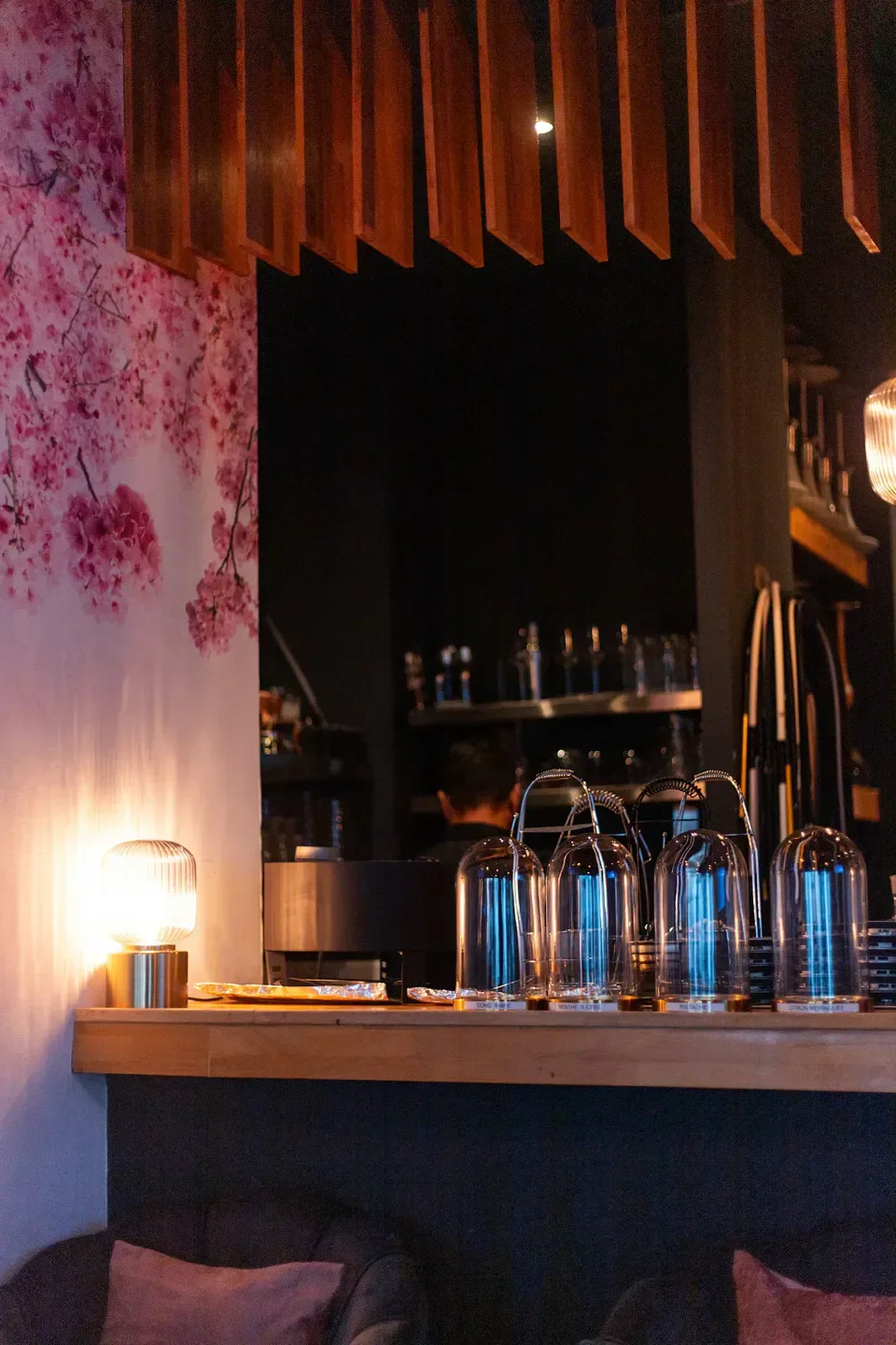 Interior details at L'Arcane in Paris: floral wall and stylish bar setup.