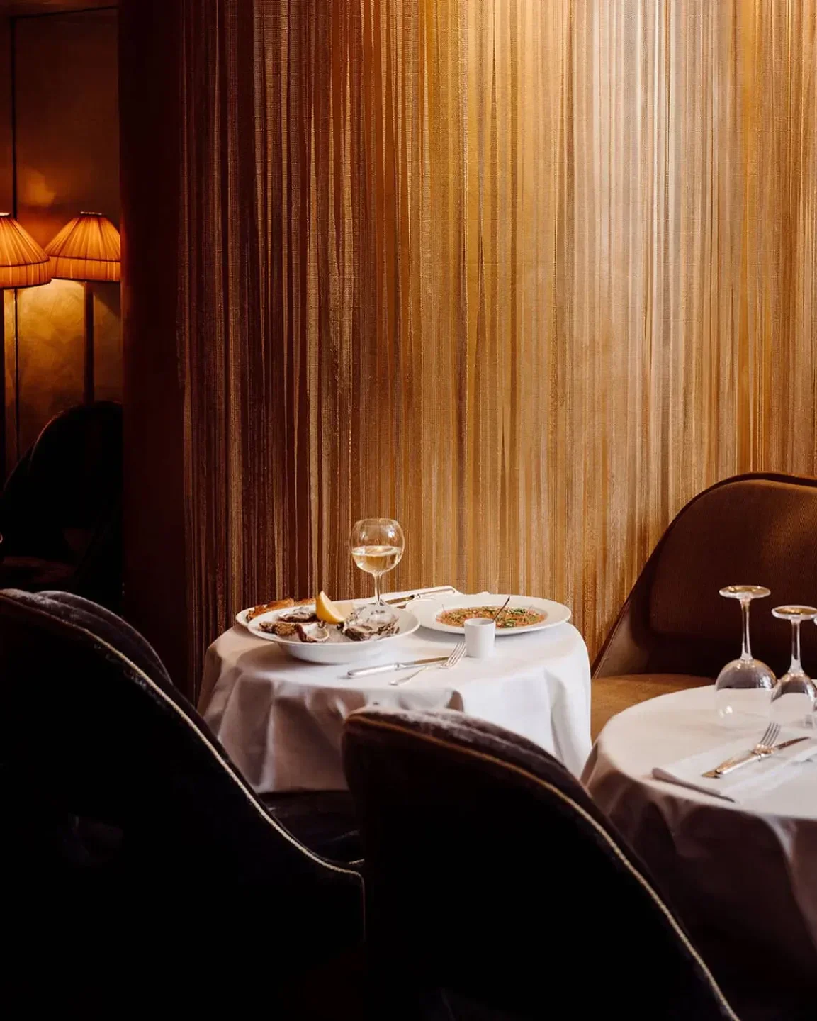 Cozy dining setting at Matignon restaurant in Paris, featuring oysters and wine.