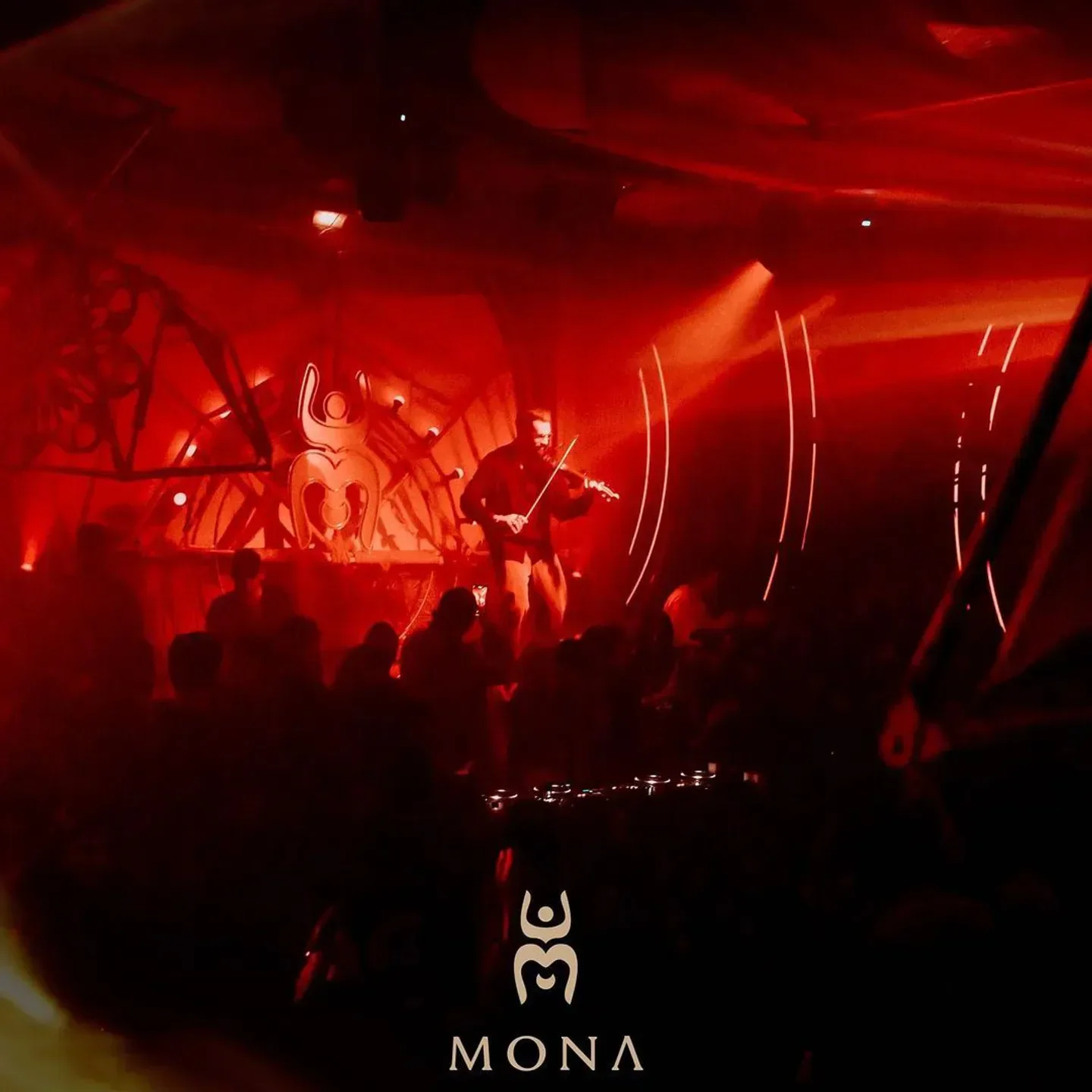 Live music at MONA nightclub in Paris. Violinist playing under red lights.