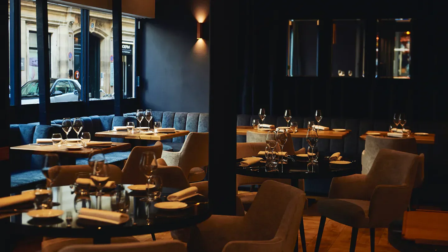 Origines Restaurant in Paris: elegant interior with tables set for a fine dining experience.
