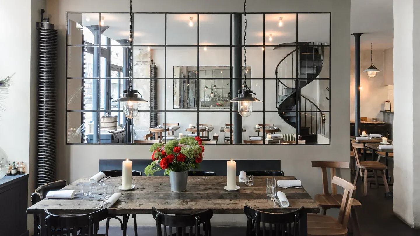 Interior of Septime restaurant in Paris, featuring a spiral staircase and elegant table setting.