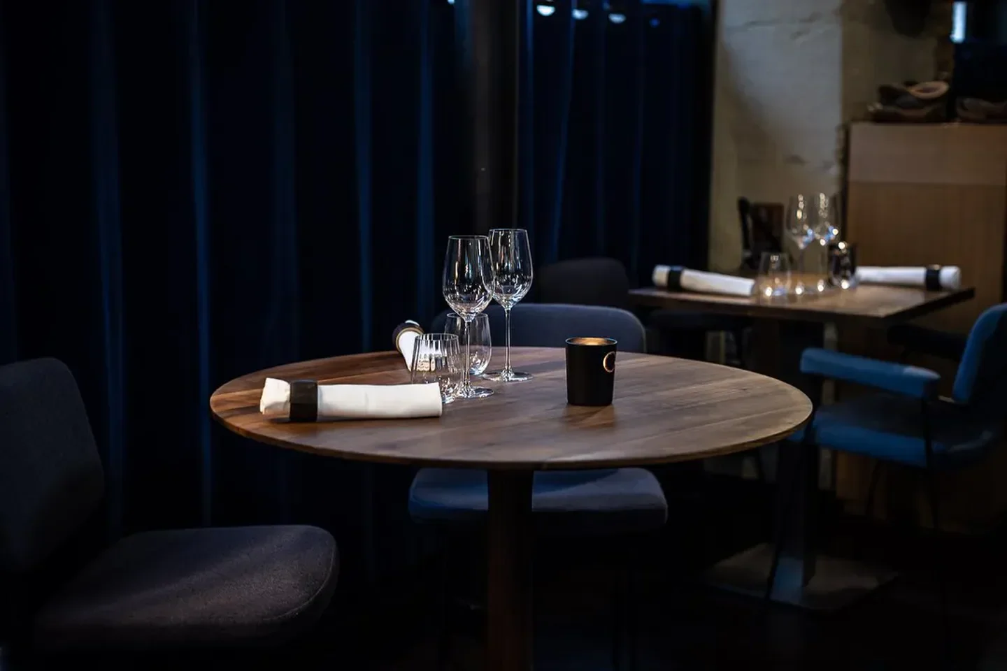Elegant dining table setting at Substance restaurant in Paris, featuring glasses and candle.